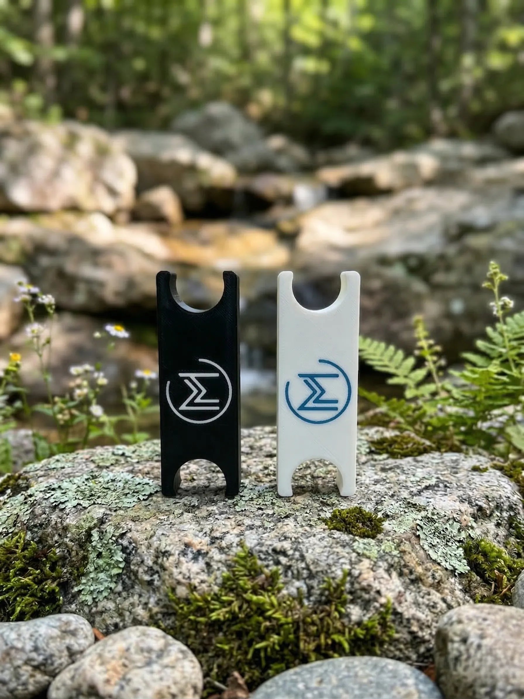 Two bottle openers on a rock in forest