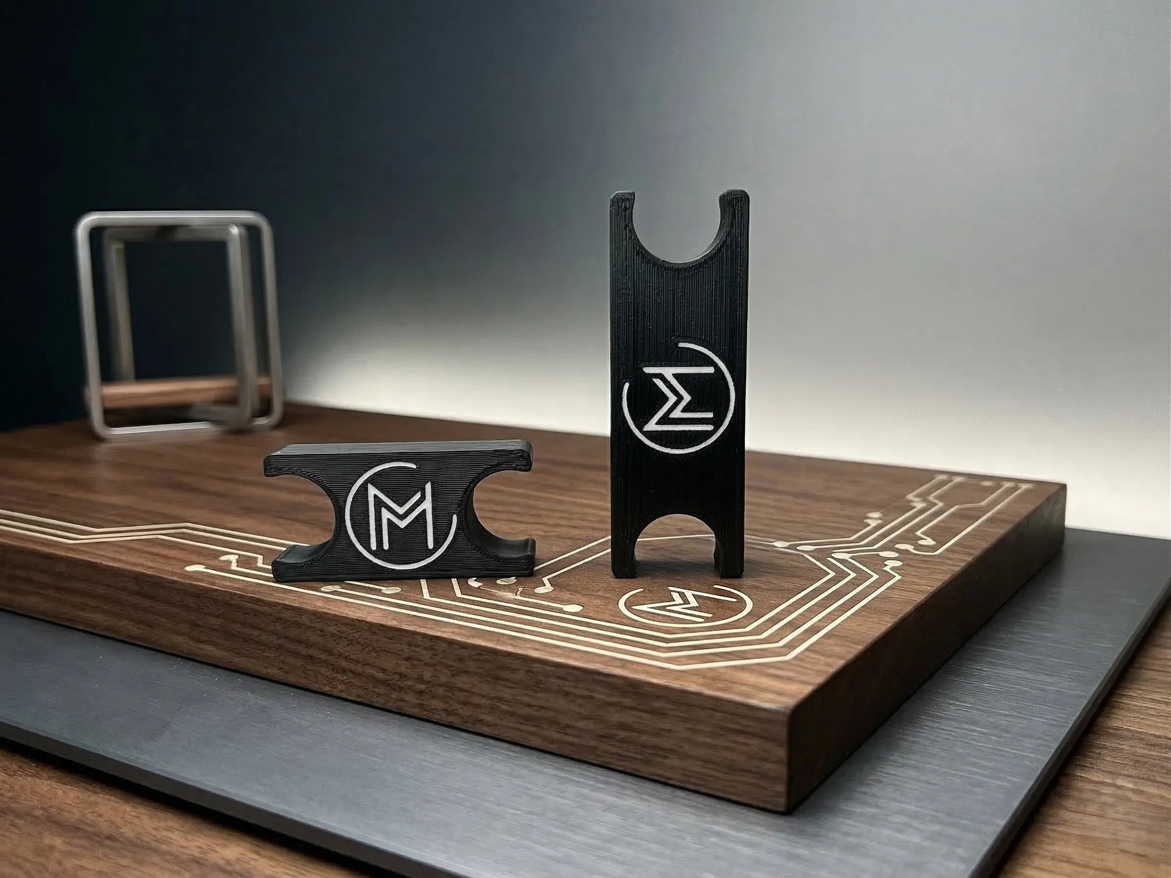 Black 3D-printed holders on wooden circuit board.