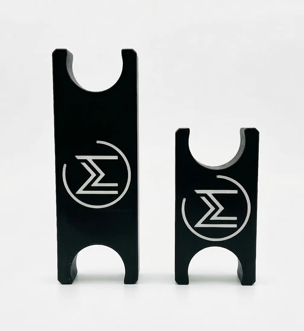 Two black metal pieces with engraved symbols