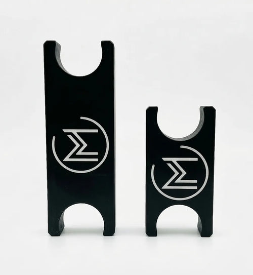 Two black metal pieces with engraved symbols