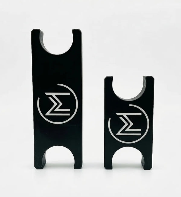 Two black metal pieces with engraved symbols