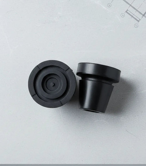 Black rubber crutch tips on gray surface